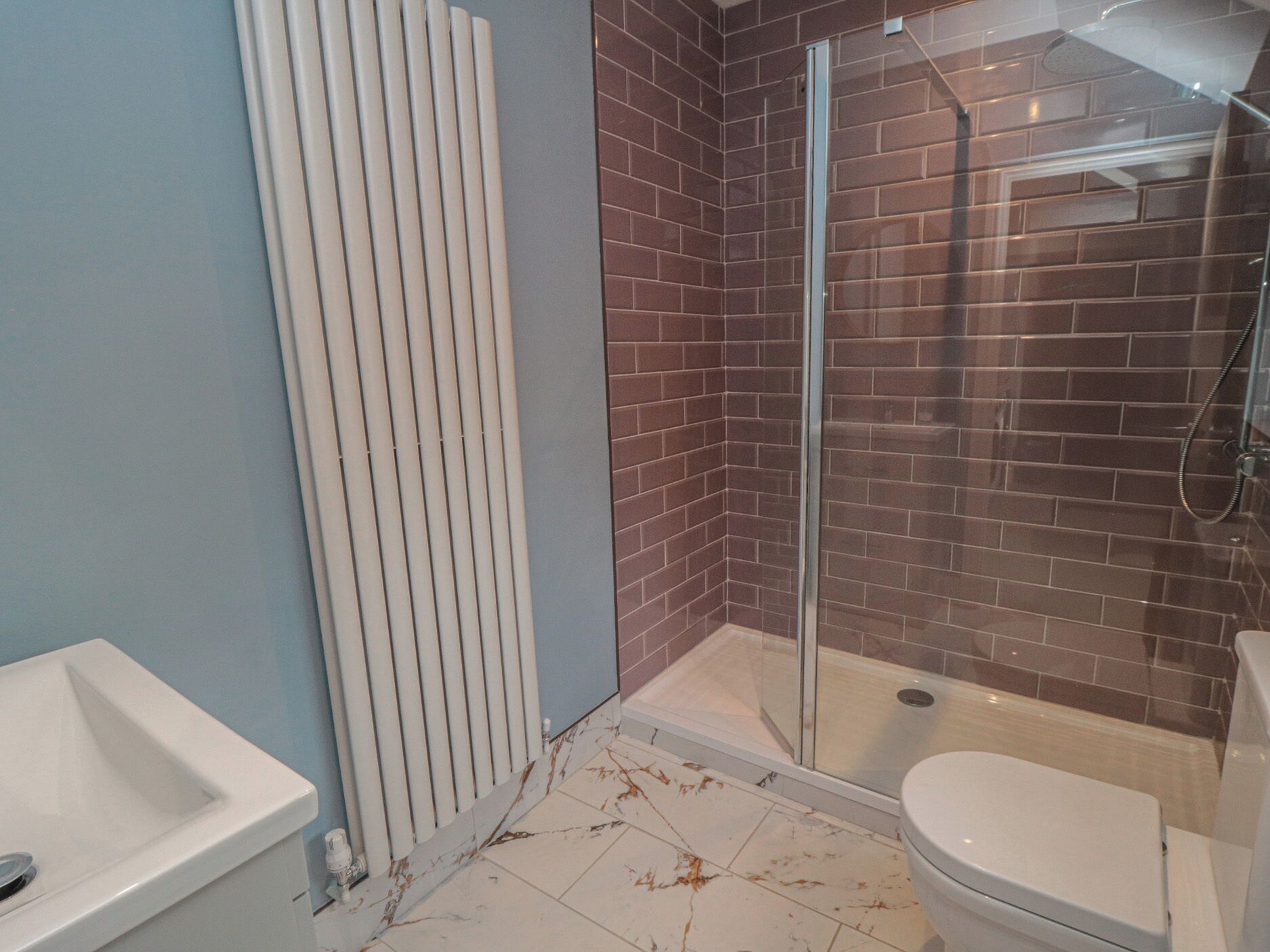 Un baño con ducha, inodoro y lavamanos.