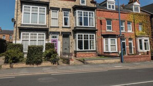 A row of terraced houses with a clear road in front. - Ruby's Retreat (Filey)