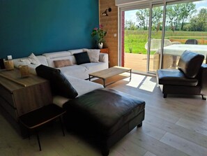 A modern living room with a sofa, coffee table, and leather ottoman.