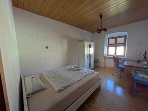 A bedroom with a bed, a wardrobe, a desk, and a chair. - Spacious apartment | 4-6 persons | 5 min to Bayernpark (Reisbach)
