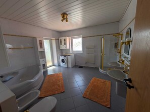 Un baño con bañera, inodoro, lavabo y ducha.