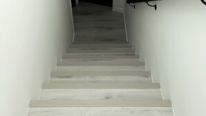 A staircase with wooden steps leading to a dark room. - Luxury 1 bedroom Basement suite (Private Entrance and Free Parking) (Winnipeg)