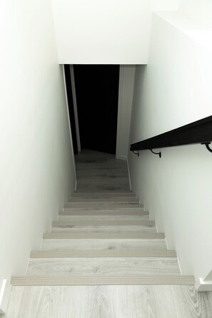 Una escalera con escalones de madera que lleva a una habitación oscura.