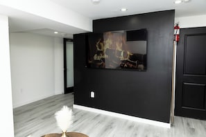 Una habitación moderna con una pared de acento negra, una obra de arte colgada y una puerta blanca.