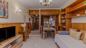 A compact living space with a TV, dining table, kitchenette, and a bed. - #366 Cozy 1BR Retreat | Private Balcony (Albufeira)