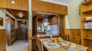 A wooden interior with a dining table set for breakfast, a kitchen in the background, and a wooden door. - #366 Cozy 1BR Retreat | Private Balcony (Albufeira)