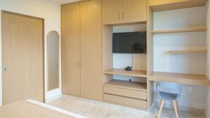 A room with a wardrobe, a desk with a chair, and a television. - Abba Suites Playa Del Carmen (Playa del Carmen)