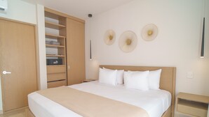 Un dormitorio con cama, armario, mesita de noche y elementos decorativos en la pared.