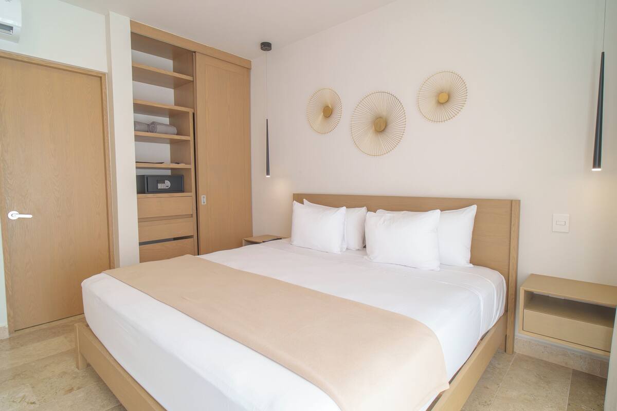 A bedroom with a bed, a wardrobe, a bedside table, and wall-mounted decorative items.