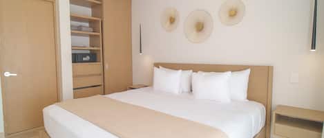 A bedroom with a bed, a wardrobe, a bedside table, and wall-mounted decorative items.
