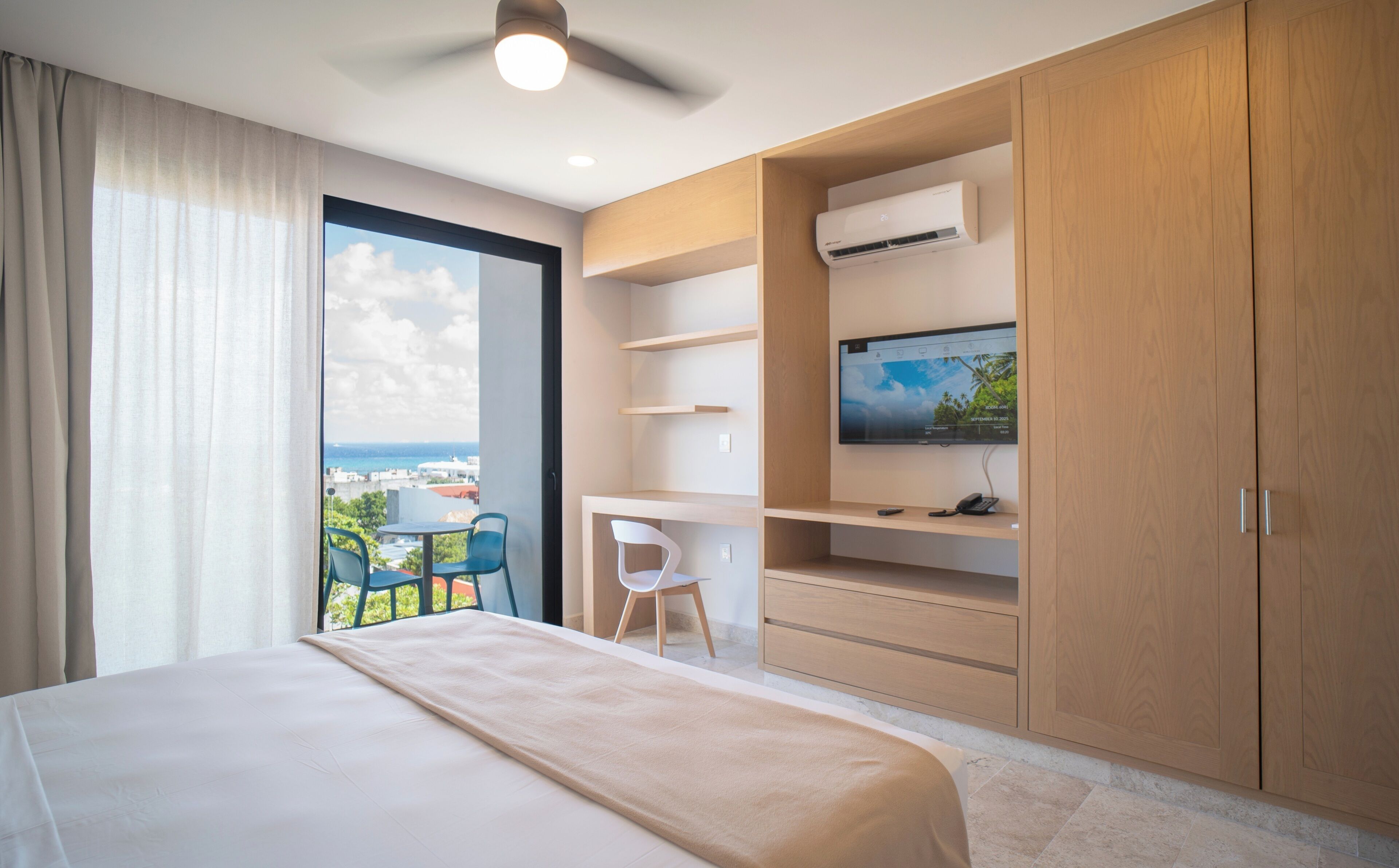 Une chambre d’hôtel avec un lit, un bureau, une télévision et une vue sur la ville.