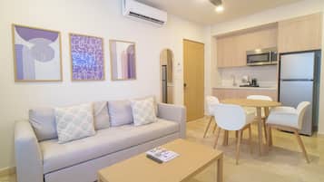 Una sala moderna con sofá, mesa de centro y un comedor con sillas.