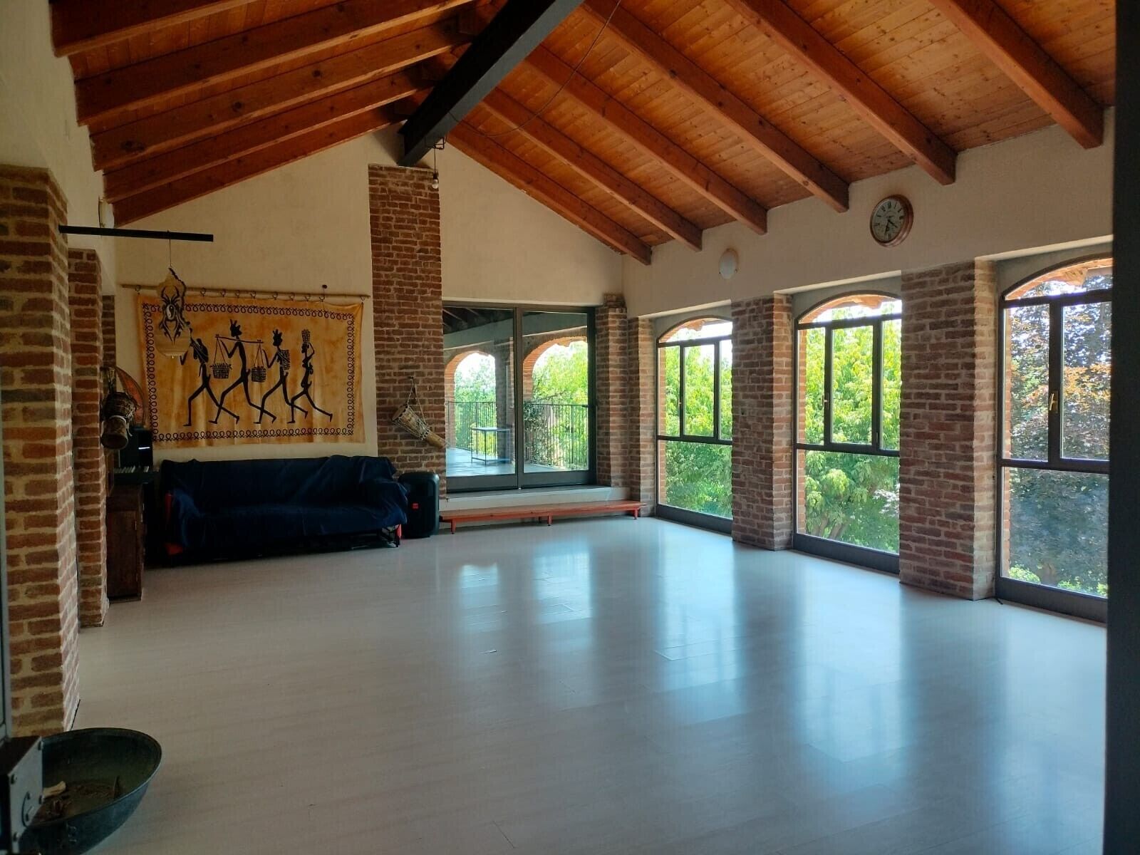 A spacious room with a high ceiling, large windows, and a brick wall.. Holiday Home 'Casa Centomila Volte Benvenuti' with Private Terrace