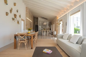 Een moderne woonkamer met een eethoek, een bank en een salontafel.