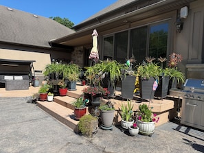 A patio area with outdoor furniture, a grill, and various potted plants. - Niagara River Idyll K *****
Luxurious King Ensuite (Fort Erie)