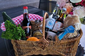 A wicker basket filled with food items and beverages, including a bottle of beer, a bottle of lemonade, and a loaf of bread. - Family stay at the educational farm | Spa included | 1h30 from Paris (Villiers-Saint-Orien)