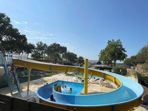 Un parc aquatique dotĂ© dâune grande piscine, dâun toboggan et dâune aire de jeux.