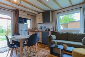 A cozy kitchen with a dining area, a sofa, and a window with curtains.