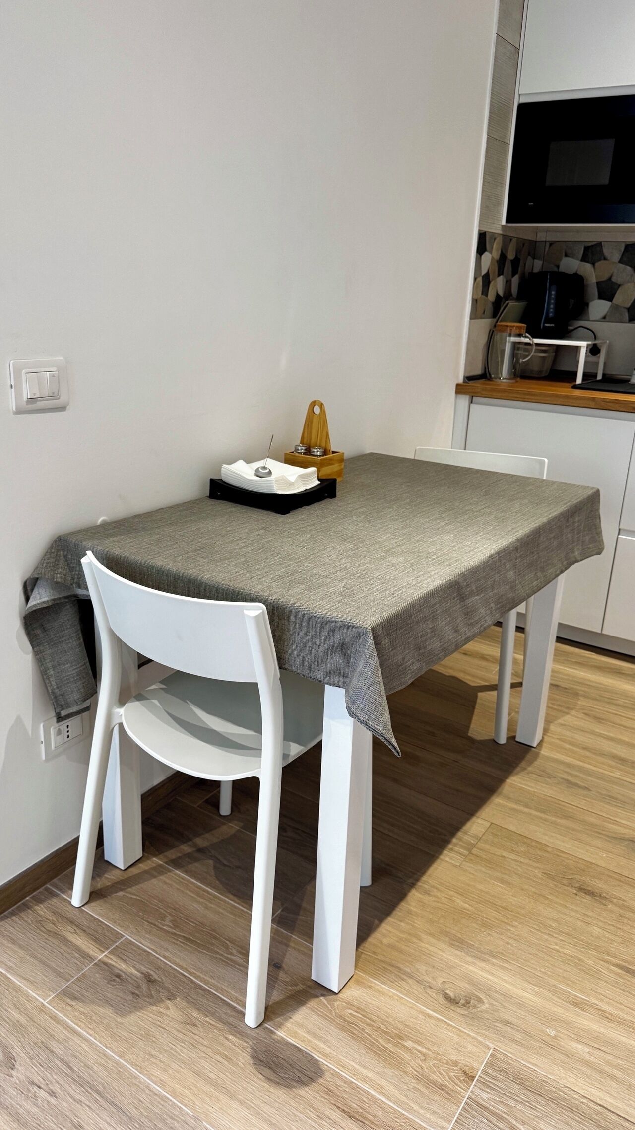 Een gezellig eetgedeelte met een tafel, stoelen en een keuken op de achtergrond.
