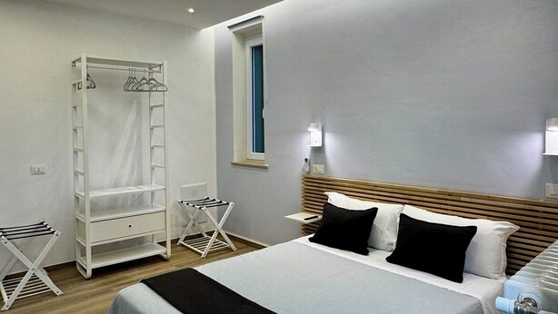 Une chambre à coucher moderne, équipée d’un lit, d’une armoire, d’un étendoir et d’un radiateur.