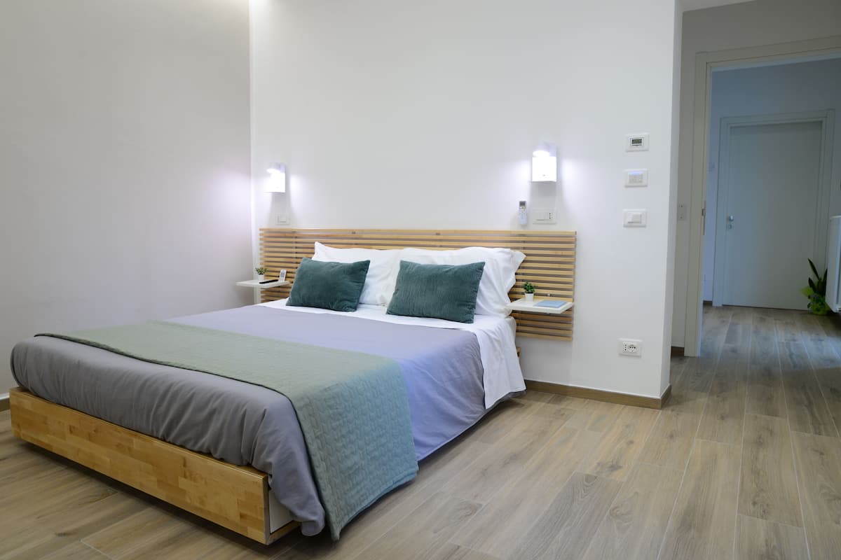 A modern bedroom with a wooden bed frame, a bedside table, and a nightstand.