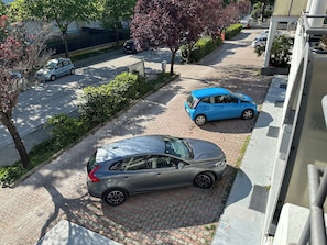Eine Wohnstraße mit parkenden Autos und Bäumen.