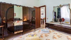 Un dormitorio con cama, cómoda, espejo y armario.