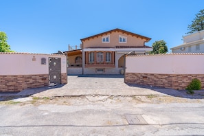 A two-story house with a front entrance, a small porch, and a garage. - Apartment 'Magnolia' with Pool, Wi-Fi and Air Conditioning (Arenella)