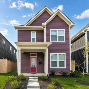A two-story house with a red door, white windows, and a front porch. - Brand-New 2026 Home • Near Downtown (Indianapolis)