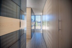 A hallway with wooden flooring, a glass partition, and a view of the outdoors. - Sweet Hill - Villa Kaye (Gustavia)