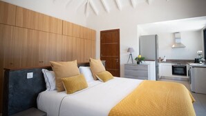 Ein modernes Schlafzimmer mit einem großen Bett, einem Holzschrank und einer Küchenzeile.