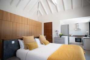 Ein modernes Schlafzimmer mit einem großen Bett, einem Holzschrank und einer Küchenzeile.