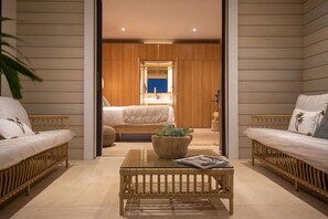 A room with a bed, two sofas, a coffee table, and a potted plant. - Sweet Hill - Villa Rosa (Petite Saline)