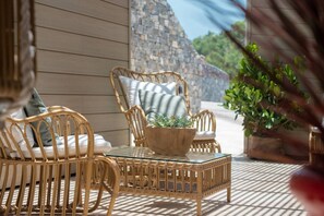 A wicker outdoor seating area with cushions, a table, and a potted plant. - Sweet Hill - Villa Rosa (Petite Saline)