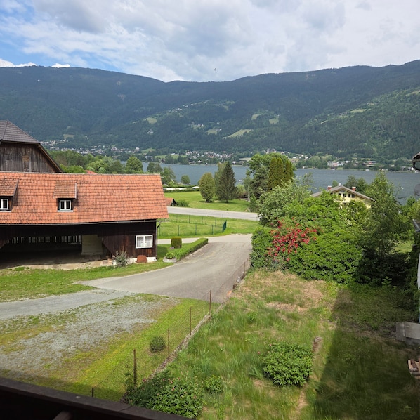 A rural landscape with a house, a barn, and a lake.