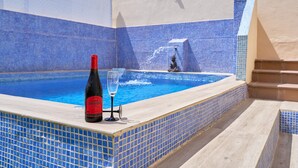 A swimming pool with blue mosaic tiles, a bottle of wine, and a glass on the edge. - Villa Oasis del Sol II – Pool – Sea Views (Urbanización Cerro Garbancito)