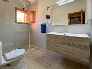 A modern bathroom with a shower, toilet, vanity, and a large mirror. - Charming rustic home in Alaró, perfect for families and groups amid nature (Alaró)