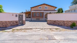 A two-story house with a front entrance, a small porch, and a garage. - Apartment 'Milu' Poolside, Wi-Fi and Air Conditioning (Arenella)