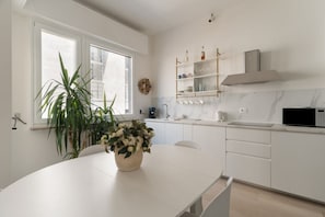 A modern kitchen with white cabinetry, a marble countertop, a built-in microwave, and a potted plant on the table. - Spacious 100m2 apartment, ideal for up to 6 guests, located on the second floor with lift.Located in the Guastalla district, it is about a 15-minute walk from the M3 Crocetta, M4 Sforza-Policlinico and M1/M4 San Babila metro stops, with numerous surface  (Milan)