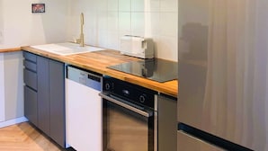 Una cocina moderna con electrodomésticos de acero inoxidable, lavavajillas y horno empotrado.