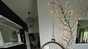 A room with a hanging chair, a mirror, and a decorative tree with lights. - Spacious, 9-bed double house in peaceful setting, 12 miles from Frankenmuth (Clio)