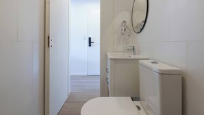A modern bathroom with a toilet, sink, and mirror. - MOT Rentals + Plaza Armenia 2B - Loft in Palermo Soho (Buenos Aires)