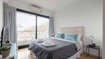 2 habitaciones, escritorio y tabla de planchar con plancha