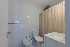 Ein Badezimmer mit Toilette, Bidet und Badewanne.