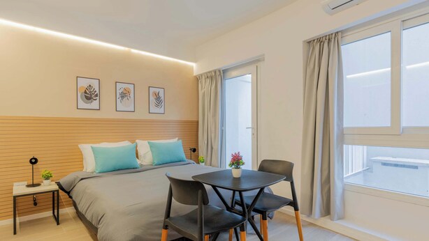 A modern bedroom with a bed, bedside table, lamp, and a view of the outside through a window. - MOT Rentals + Plaza Armenia 1D - Loft in Palermo Soho (Buenos Aires)