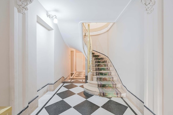 A staircase with patterned carpet runners, a checkered floor, and a white interior. - LDV Aparts 2C Entrepiso by MOT Rentals (Buenos Aires)