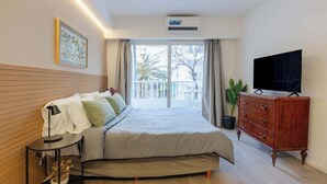 A bedroom with a bed, bedside table, dresser, TV, and a balcony with a view. - MOT Rentals Plaza Armenia - 4 Lux Lofts in Palermo Soho (Buenos Aires)