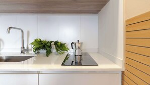 A kitchen with a stainless steel sink, a wooden countertop, and a coffee maker. - MOT Rentals Plaza Armenia - 4 Lux Lofts in Palermo Soho (Buenos Aires)