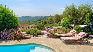A pool area with lounge chairs, a small table, and a hammock. - Villa "Le Panorama d’Azur – Pool" with Sea View, Wi-Fi, and Air Conditioning (Valbonne)