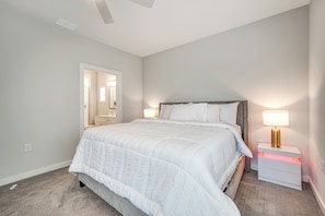 A bedroom with a large bed, bedside tables, a nightstand, and a mirror.